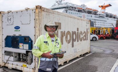 Coughlin poses in front of a Tropical shipping container, wearing a cowboy hat.