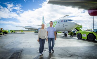 Lan and Ko walk away from an Aloha Air Cargo jet sitting on the tarmac.