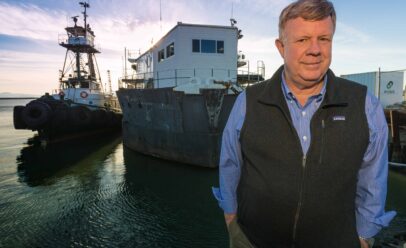 Mulcahy poses on a dock in front of BARGE 1.