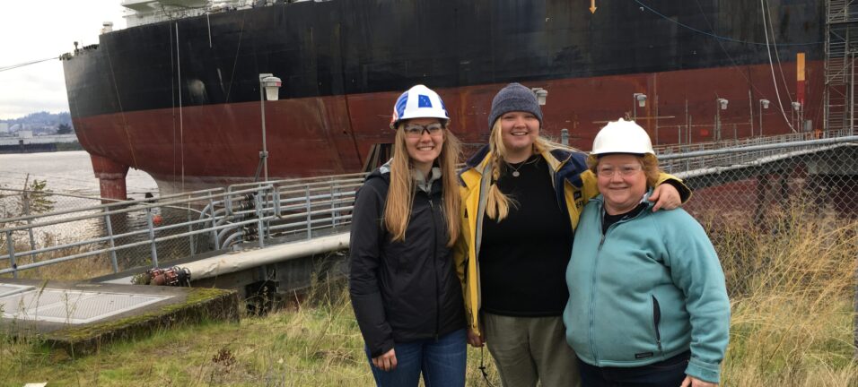 Hays with her daughters standing in front of an ATC vessel