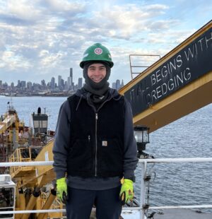 Grady Gralewski, Great Lakes Dredge & Dock 3rd Mate stands on deck of a hopper dredge